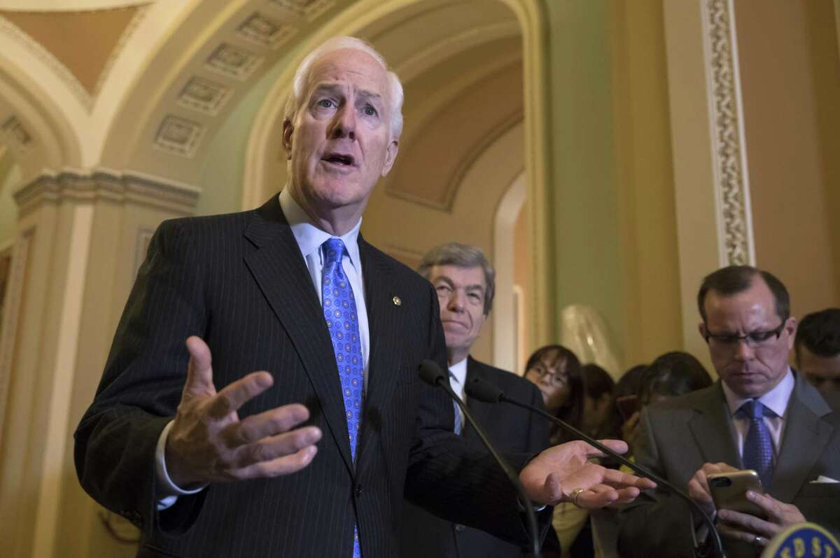 Majority Whip John Cornyn, R-Texas, joined at right by Sen. Roy Blunt, R-Mo., answers a question about the mass shooting at a Texas church in November. He has sponsored a bill to penalize entities that don’t properly report convictions to a federal background check database that screens for gun purchases.