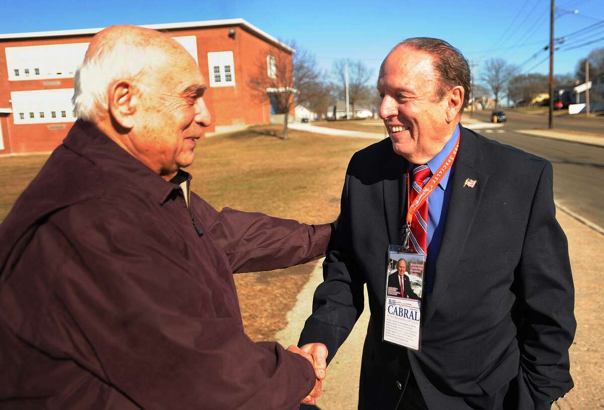 Voter Bob Richard, left, shakes hands with Republican candidate for state representative for the 120th District Bill Cabral outside the polls at Wooster Middle School in Stratford, Conn. on Tuesday, February 27, 2018.