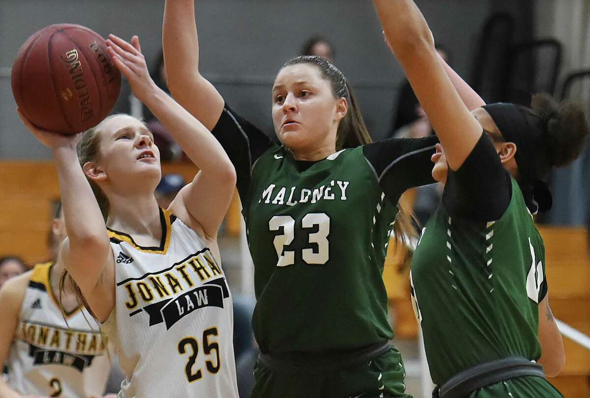 Law sophomore Olivia Kowalski looks for the hoop battling beat Maloney seniors Melanie Polanco (23) and Dasia White (21), Tuesday, Feb. 27, 2018, in a class L first round matchup of the CIAC state tournament at Jonathan Law High School in Milford. Law won, 62-28.