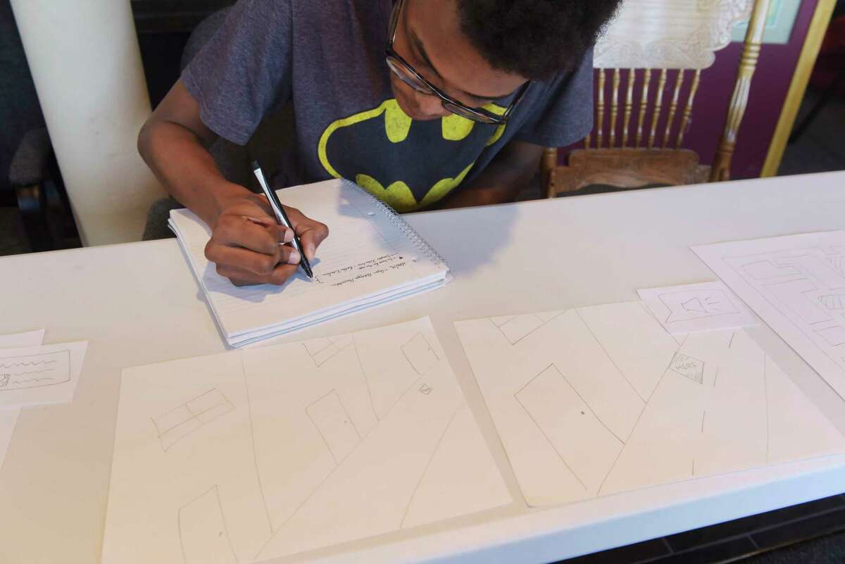 RPI junior Sheldon Noel writes down ideas for the augmented reality portion of a mural at the Cohoes Visitor Center on Wednesday, Feb. 28, 2018, in Cohoes, N.Y. RPI professors and students held an event to hear from members of the community for their ideas on a mural that incorporates an augmented reality overlay that will be placed on the outside wall of 289 Ontario Street. (Paul Buckowski/Times Union)