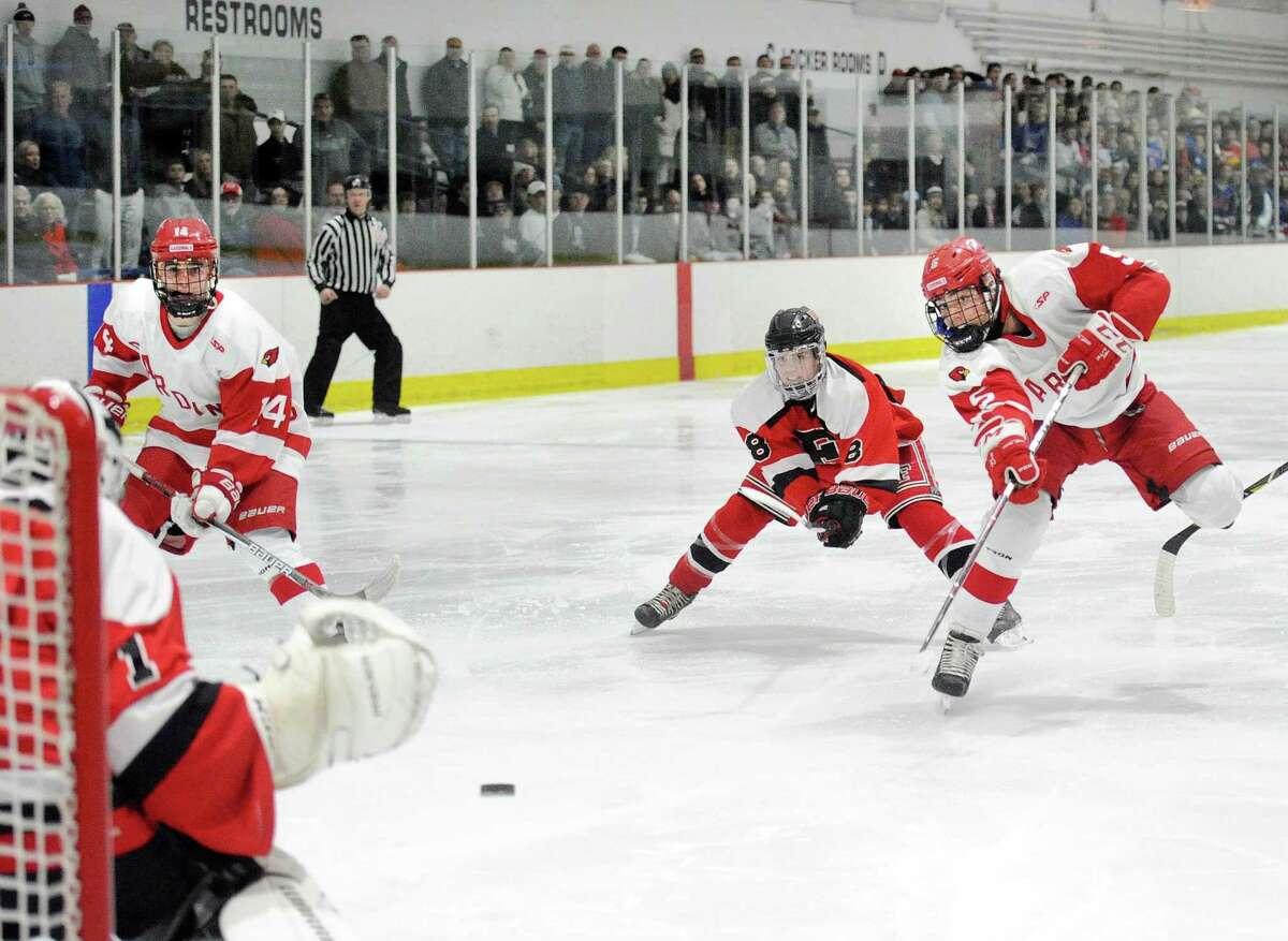 At right, Nicolas Pelletier-Martinelli (#5) of Greenwich beats Faifield defender Kyle Mazza (#8), getting off a second period slapshot that beat Fairfield goalie Dawson Gunn, left, for a goal during the FCIAC boys ice hockey semi-final game between Greenwich High School and Fairfield Combined High Schools at the Darien Ice Rink, Conn., Wednesday, Feb. 28, 2018.