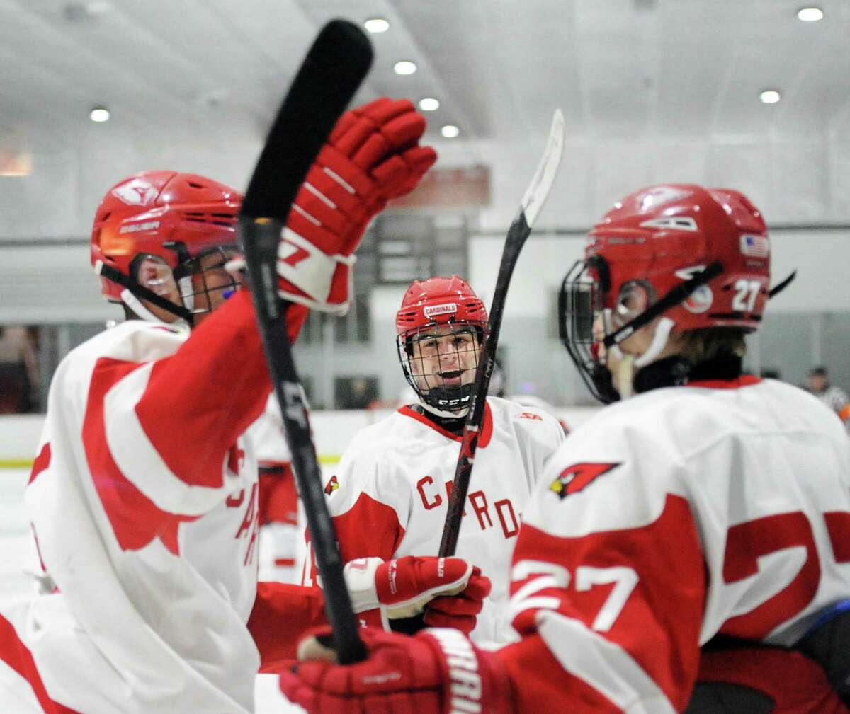 At center, Greenwich’s Matthew Davey smiles after teammate Nicolas Pelletier-Martinelli, left, scored a second period goal. Joining the celebration at right is Nikita Kovalev on Wednesday in Greenwich.