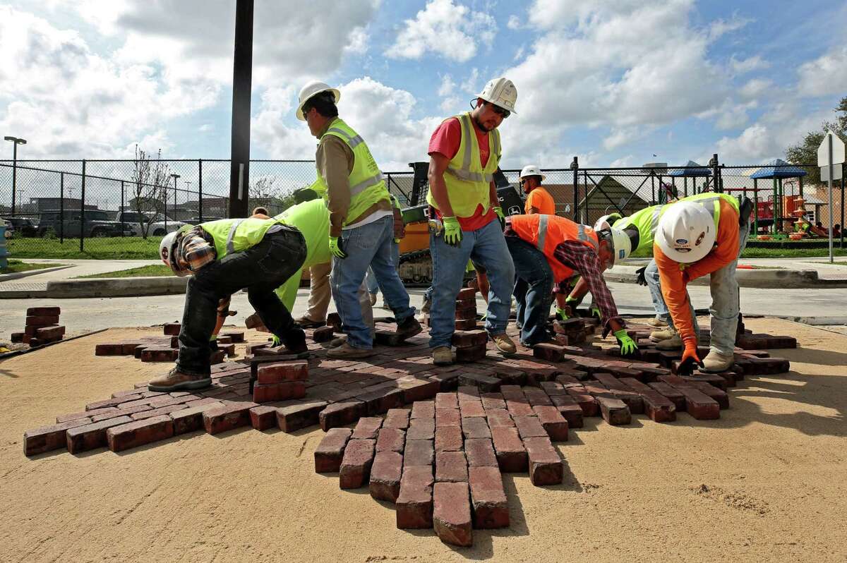 Houston Public Works crews re-install the historic bricks on the corner of Andrews and Genesee streets in Freedman's Town Wednesday, Feb. 28, 2018, in Houston.