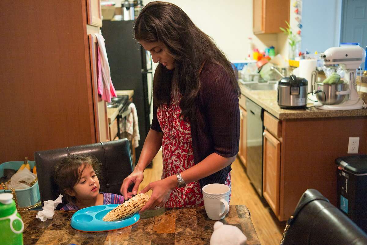 Karishma Chawla makes corn on the cob for her daughter Naisha at her home in San Jose, Calif. on Friday, Aug. 18, 2017. For decades spouses of H-1B visa holders could not work, until two years ago when President Obama issued a work authorization. But now his authorization is under threat by the Trump administration who is trying to rid these visa holders from the ability to work.