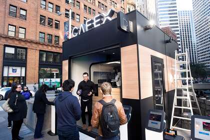 Kyule Woollum leaves Cafe X after being served a mocha by a robot barista in 2018. The One Bush Plaza location is one of three to close this year.