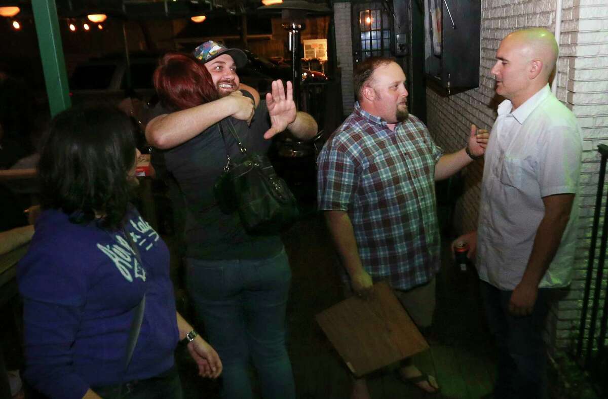 The Harp long-time customers greet and hug each other on the bar's closing night on Wednesday, Feb. 28, 2018, in Houston.