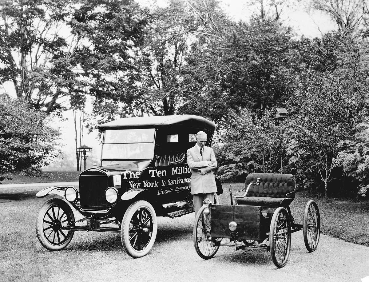 在这份未注明日期的公司宣传单上，亨利·福特站在1896年的四轮车(右)和第1000万辆福特汽车T型车之间。2003年11月18日，星期二，这家汽车制造商生产了它的第3亿辆汽车。(美联社图片/福特汽车公司)