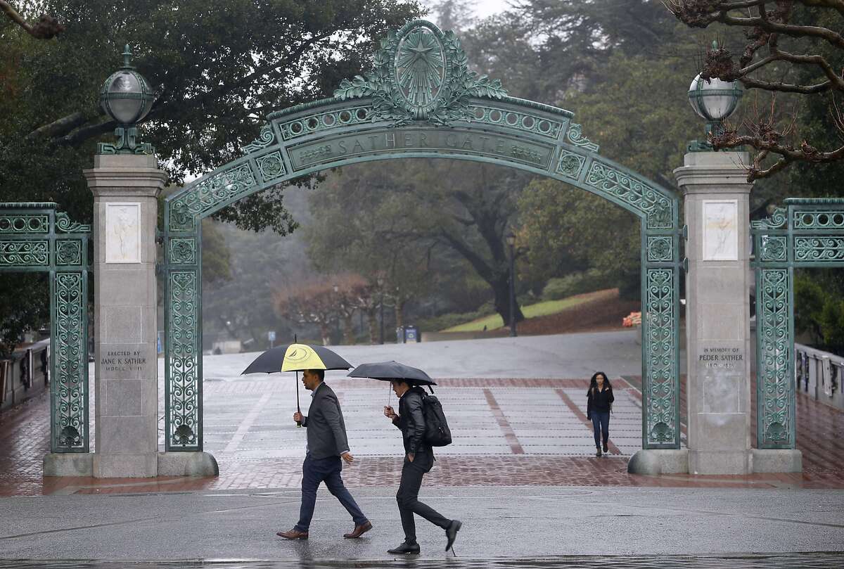 Pedestrians walk past Sather Gate at UC Berkeley in light rain on Saturday, Jan. 16, 2016. Another major rainstorm is due to soak the Bay Area tomorrow.