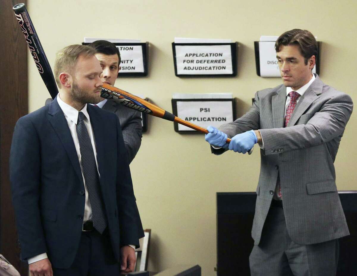 Prosecutors Matthew Ludowig (left) and Josh Somers demonstrate how they suggest that bats were used on a a victim as testimony is heard on February 28, 2018 in the trial of Gabriel Moreno, accused of killing Jose Luis Menchaca.