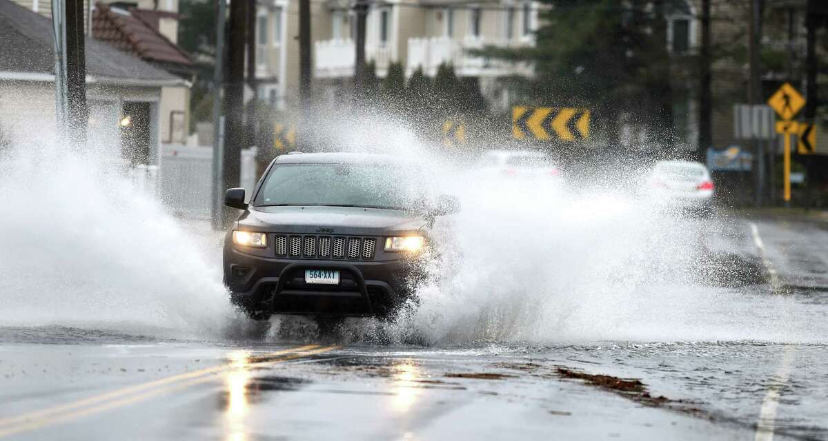 Cars travel through a flooded Merwin Ave. in Milford on March 2, 2018.