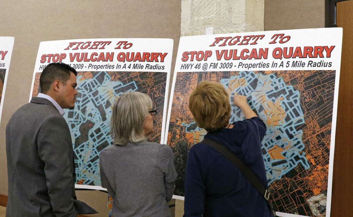 FILE PHOTO: Audience examine posters before the beginning of a public hearing on the proposed Vulcan Materials quarry in Comal County that was held in February.