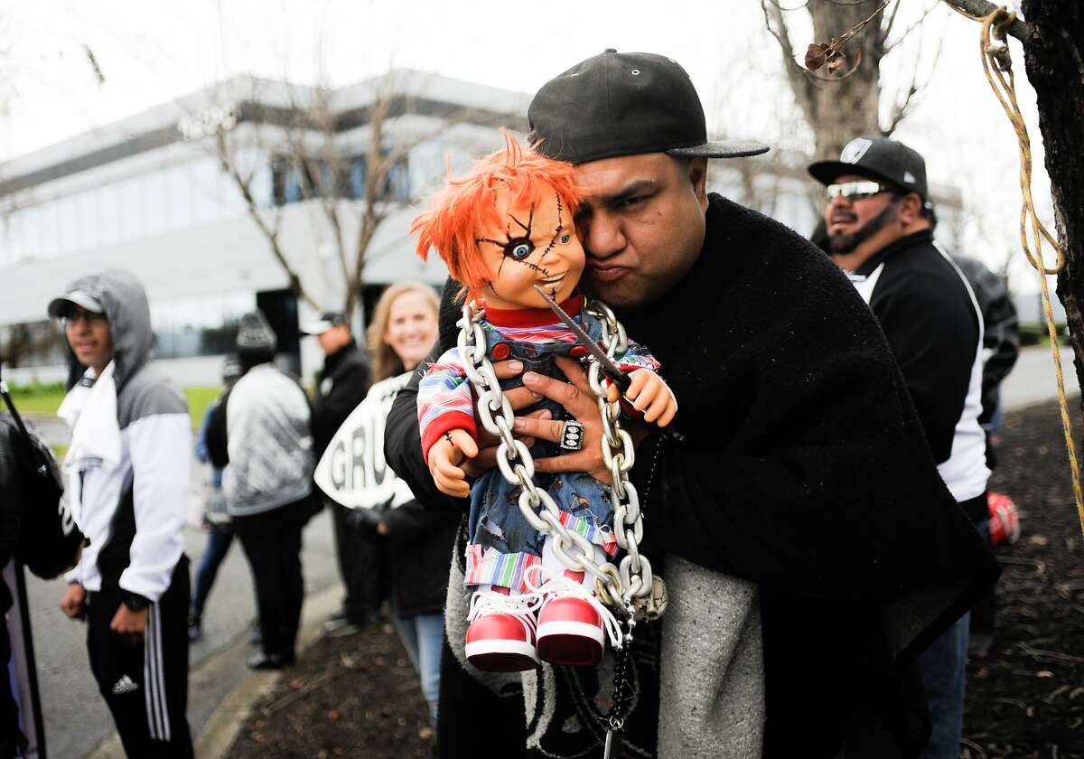 A fan holds a Chucky doll during the second half of an NFL football game  between the Oakland Raiders and the Denver Broncos in Oakland, Calif.,  Monday, Dec. 24, 2018. (AP Photo/D.