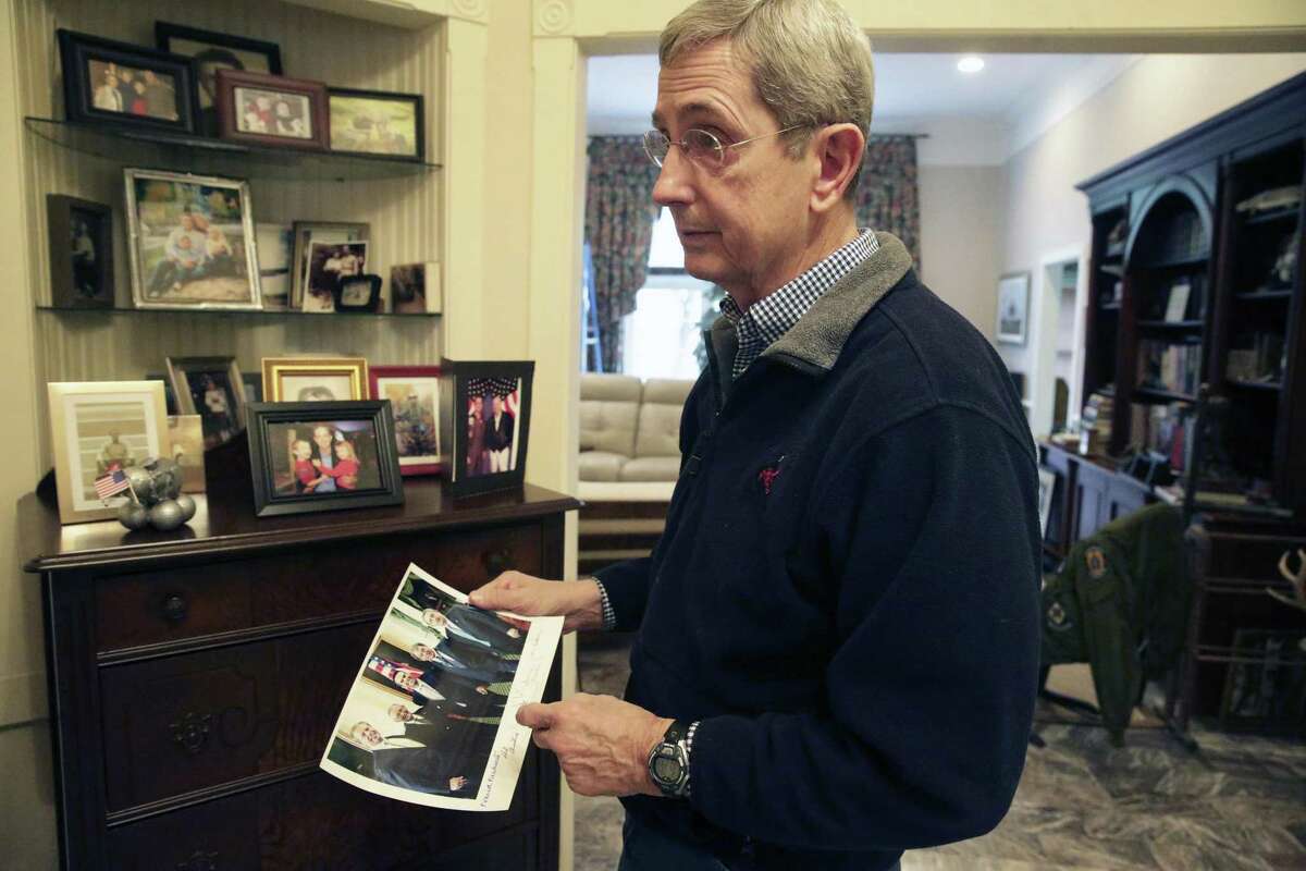 Jerry Patterson, candidate for Texas Land Commissioner, shows a picture of a group of lawmakers he knew at the capitol as he talks at his home in Austin in February.