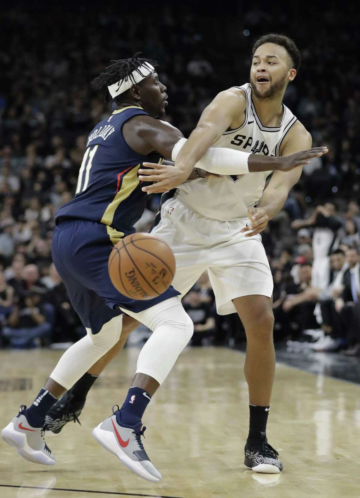 San Antonio Spurs forward Kyle Anderson (1) pass the ball around New Orleans Pelicans guard Jrue Holiday (11) during the second half of an NBA basketball game, Wednesday, Feb. 28, 2018, in San Antonio. New Orleans won 121-116. (AP Photo/Eric Gay)