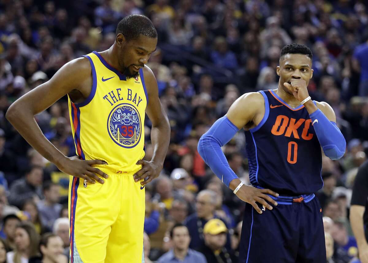 Golden State Warriors' Kevin Durant, left, stands next to Oklahoma City Thunder's Russell Westbrook during the first half of an NBA basketball game Saturday, Feb. 24, 2018, in Oakland, Calif. (AP Photo/Marcio Jose Sanchez)
