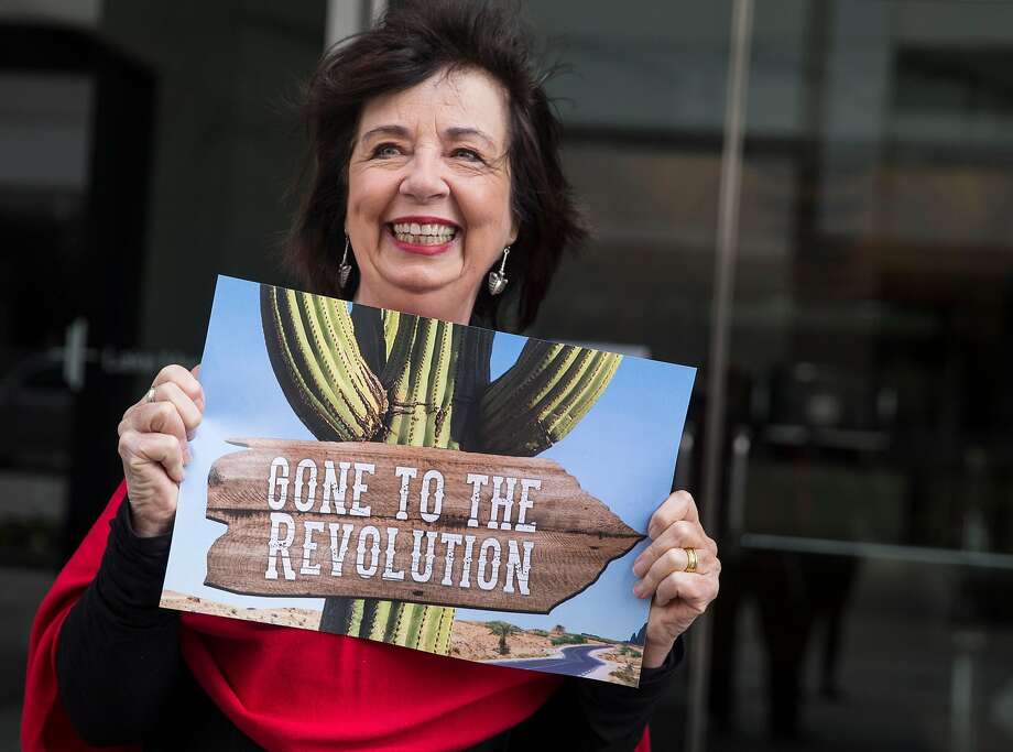 RoseAnn DeMoro shows a sign at her retirement party in Oakland. Photo: Jessica Christian, The Chronicle