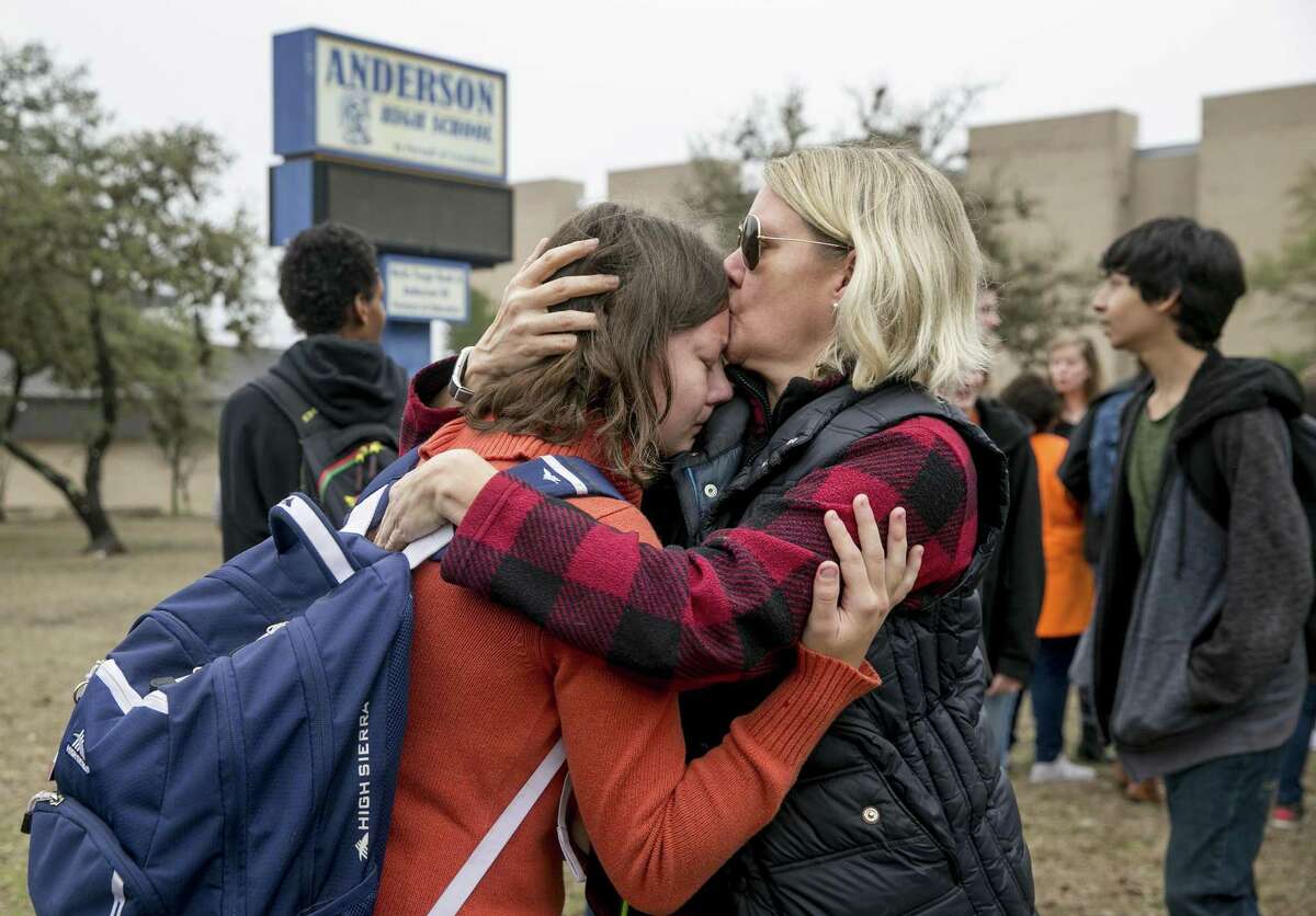 Julie Olmann comforts her 15-year-old daughter, Tori Gregory, during a walkout and demonstration for gun control at Anderson High School in Austin, Texas, on Friday Feb. 23, 2018. (Jay Janner)/Austin American-Statesman via AP)