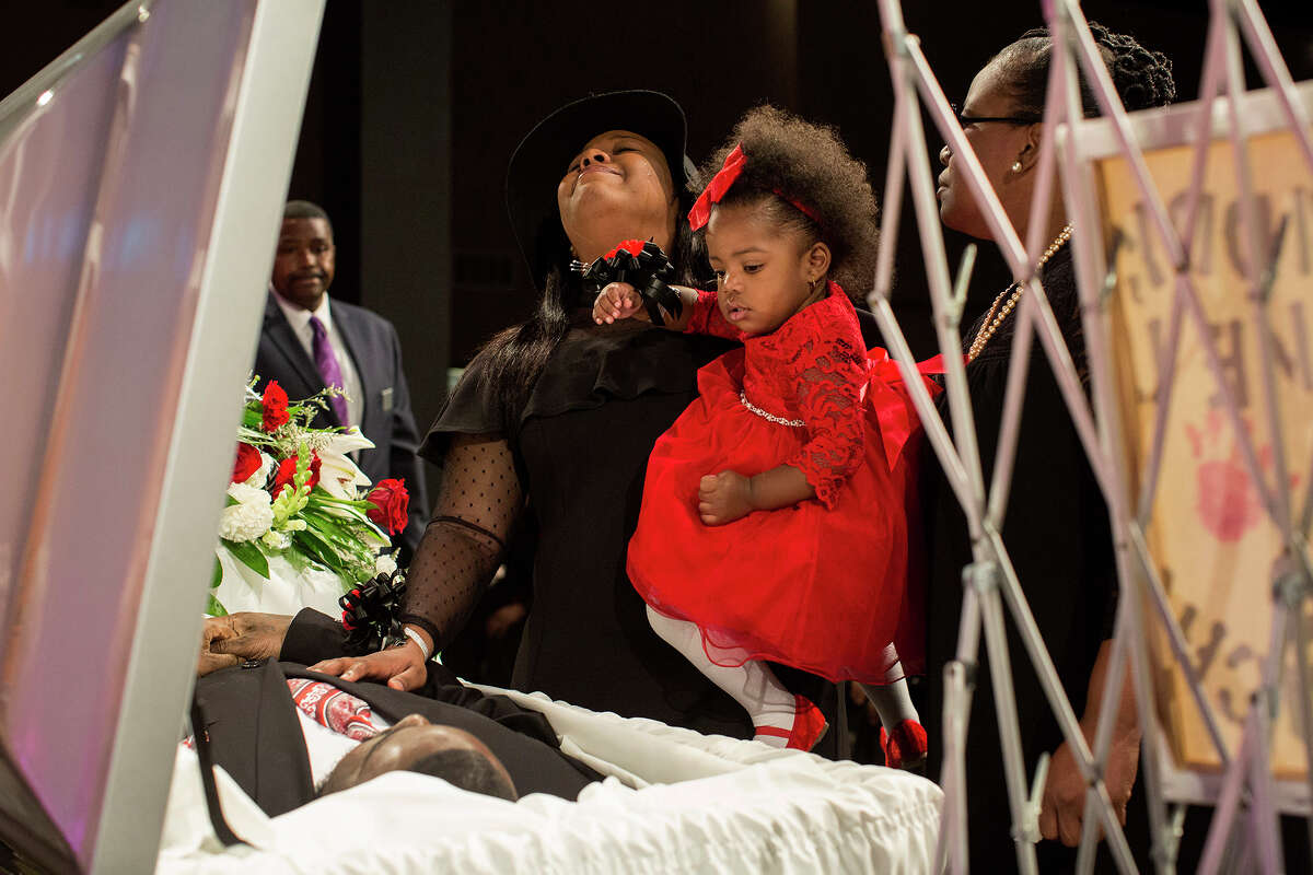 Simone McFarlan, holds her daughter, Kaydence Polk, 1, as she grieves over Chris Polk, her best friend of 18 years and Kaydence's father, during the funeral for Polk at Place for Life church in San Antonio on Friday, March 2, 2018. Polk, a local rap artist, was shot and killed at the age of 25 after a perfomance last weekend. McFarlan and Polk met in third grade when she was a cheerleader for his youth football team. "He was a huge teddy bear with a heart of gold," McFarlan said. At right is McFarlan's mother, Andrea McFarlan.