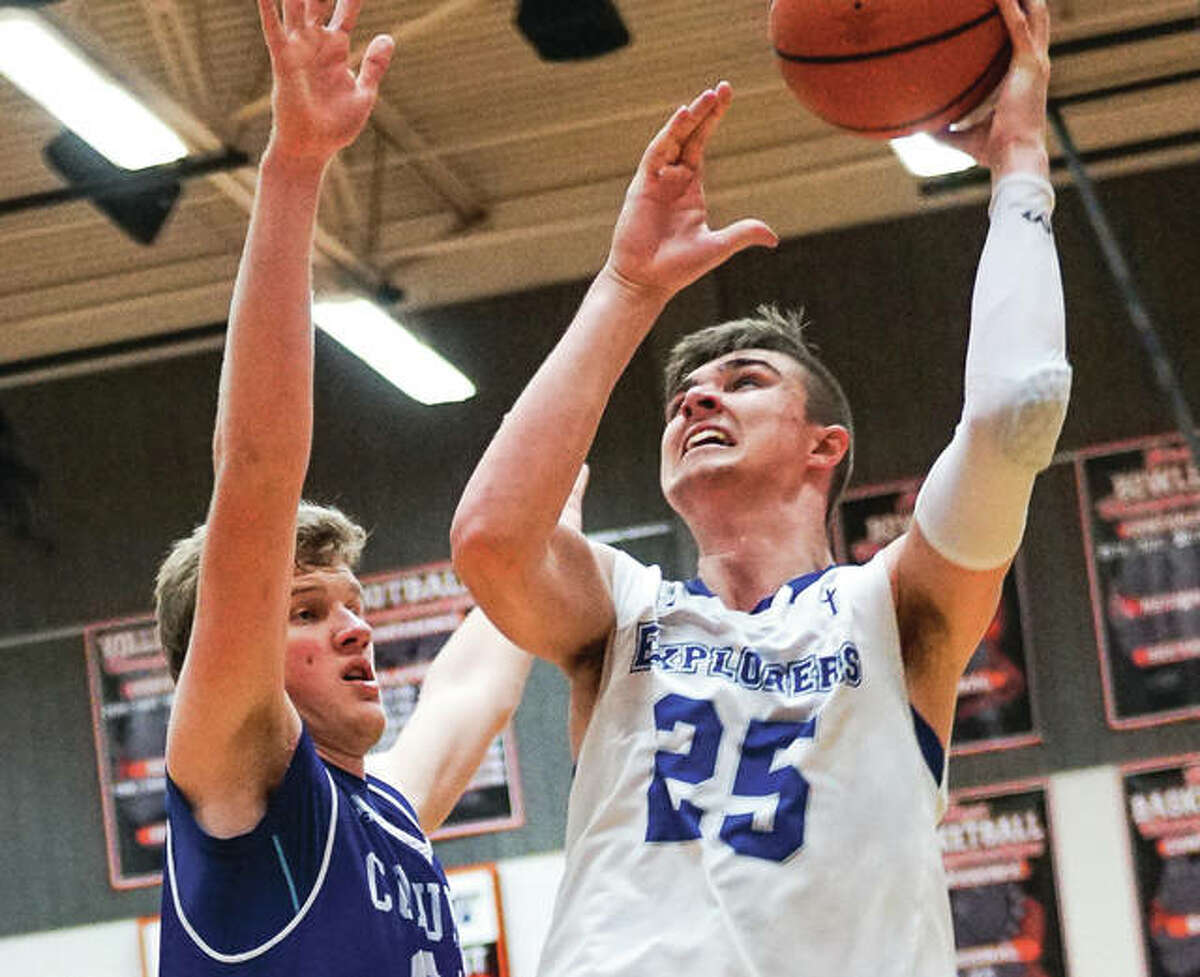 Marquette Catholic’s Jake Hall (right) looks to shoot over a Columbia’s Jon Peterson during the championship game of the Waterloo Class 3A Regional on Friday night.