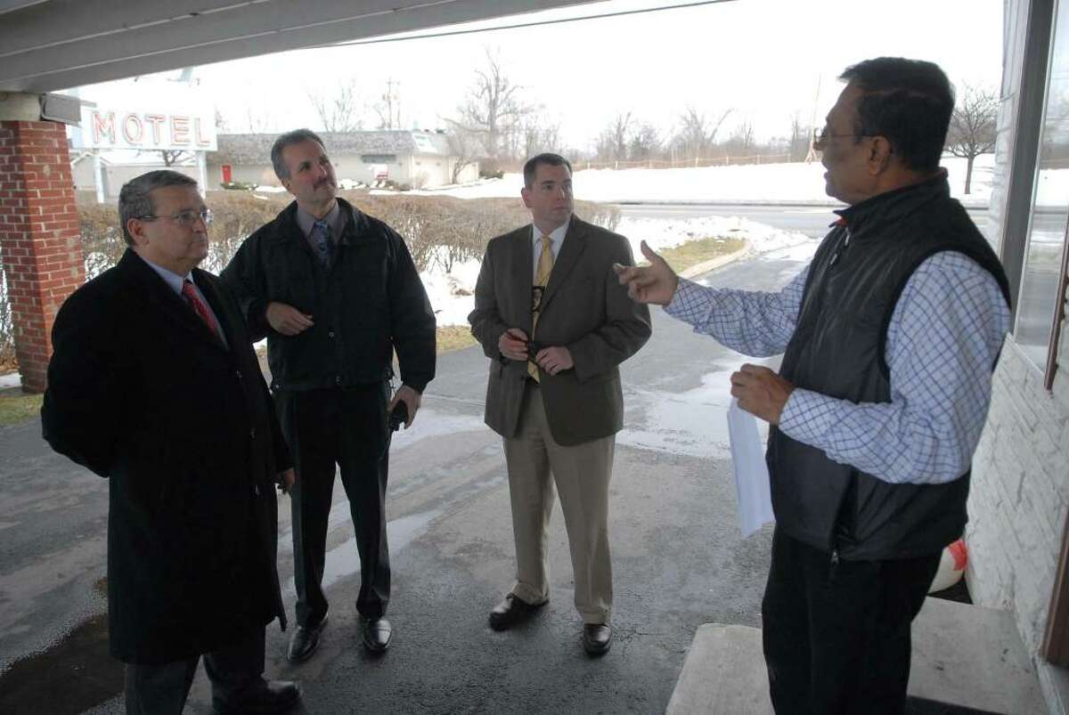 Colonie Town attorney, Michael Magguilli, left, Colonie Police detective Sgt. John Archambault, 2nd from left, and Colonie Police Sgt. Bob Barrett, 3rd from left, talk with Sycamore Motel owner Sam Patel at his motel in Colonie, NY on Monday, Dec. 14, 2009 during a inspection of some of the town's motels to check to see if they are in compliance of the new sex offenders law. (Paul Buckowski / Times Union)