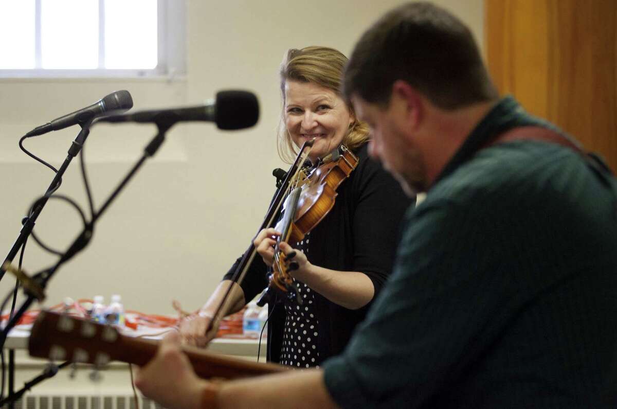 Traditional Irish fiddler Deirdre McMorrow, smiling, and guitarist/vocalist Paul Pender, perform together during a free concert at the Seymour Public Library in Seymour, Conn., on Saturday, Mar. 3, 2018. Funding for this concert was provided through a grant from the Matthies Foundation.