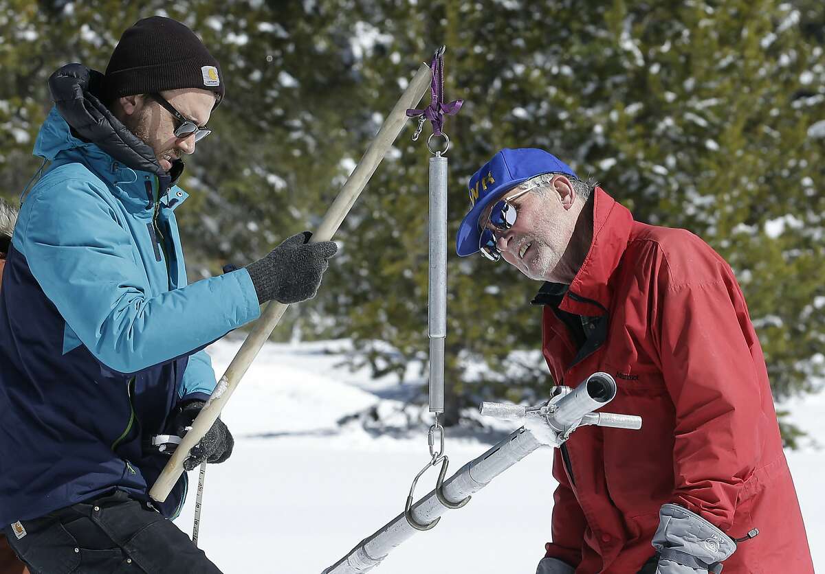 Frank Gehrke, chief of the California Cooperative Snow Surveys Program for the Department of Water Resources, right, reads the weight of the snow sample, on a scale held by Dylan Chapple, of fellow with the California Council of Science and Technology, during a supplemental snow survey Monday, March 5, 2018, near Echo Summit, Calif. The snow survey showed the snow pack at this location at 41.1 inches deep with a water content of 9.4 inches. (AP Photo/Rich Pedroncelli)