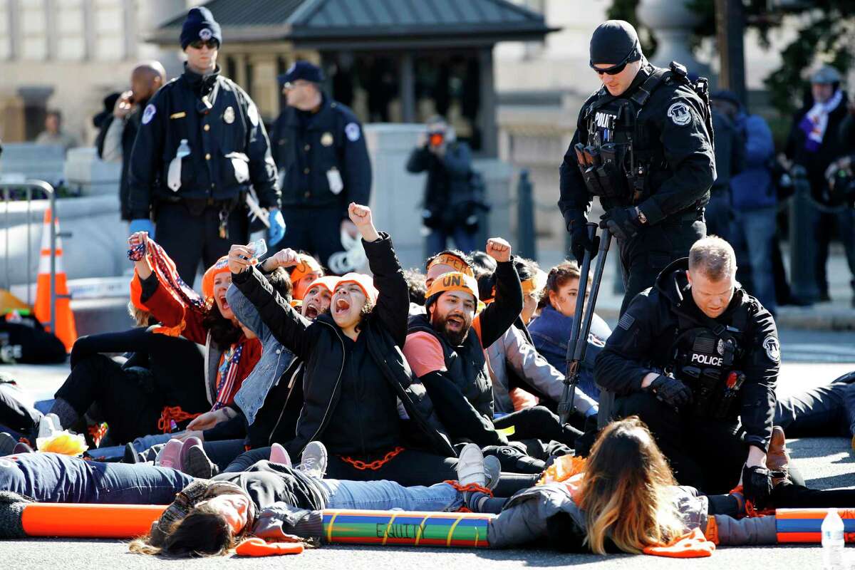 U.S. Capitol Police use bolt cutters to break chains locking together supporters of the Deferred Action for Childhood Arrivals (DACA) program, as the protesters cheer in support of DACA, Monday, March 5, 2018, on Capitol Hill in Washington. The protesters were participating in an act of civil disobedience after a march in support of DACA.
