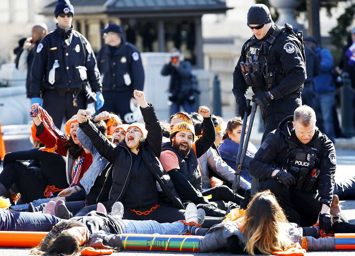 U.S. Capitol Police use bolt cutters to break chains locking together supporters of the Deferred Action for Childhood Arrivals (DACA) program, as the protesters cheer in support of DACA, Monday, March 5, 2018, on Capitol Hill in Washington. The protesters were participating in an act of civil disobedience after a march in support of DACA. (AP Photo/Jacquelyn Martin)