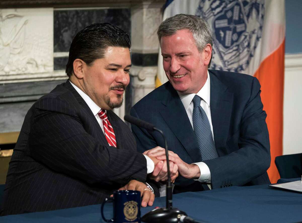 In this photo provided by the Mayoral Photography Office, Richard A. Carranza, left, is introduced by New York Mayor Bill de Blasio, right, as his new choice to lead the nation's largest school system Monday, March 5, 2018, at City Hall in New York. Carranza, who has been the superintendent in Houston since August 2016 and previously was superintendent of the San Francisco school system, has been appointed to replace Chancellor Carmen Farina, who's retiring. (Ed Reed/Mayoral Photography Office via AP)