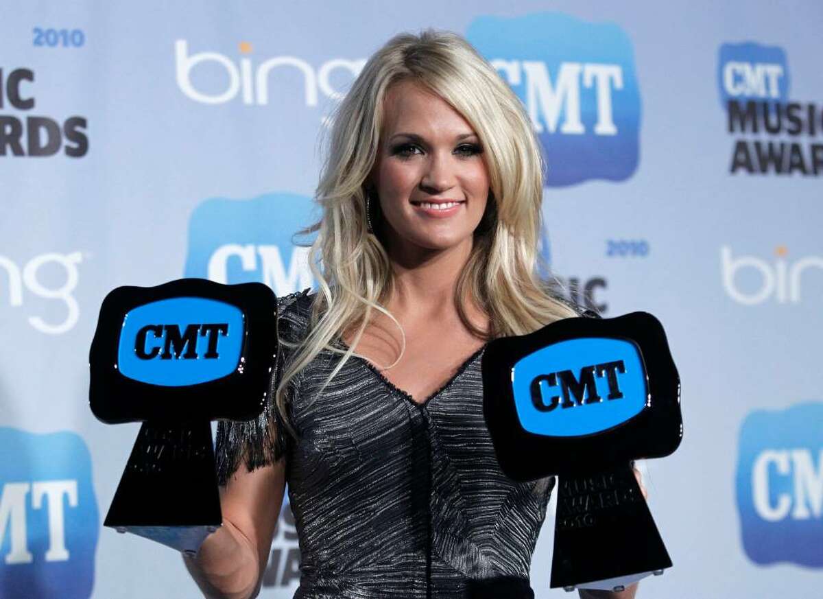 Country singer Carrie Underwood poses with her Video of the Year award and CMT Performance of the Year award in the press room at the 2010 CMT Music Awards, in Nashville, Tenn. on Wednesday, June 9, 2010. (AP Photo/Peter Kramer)