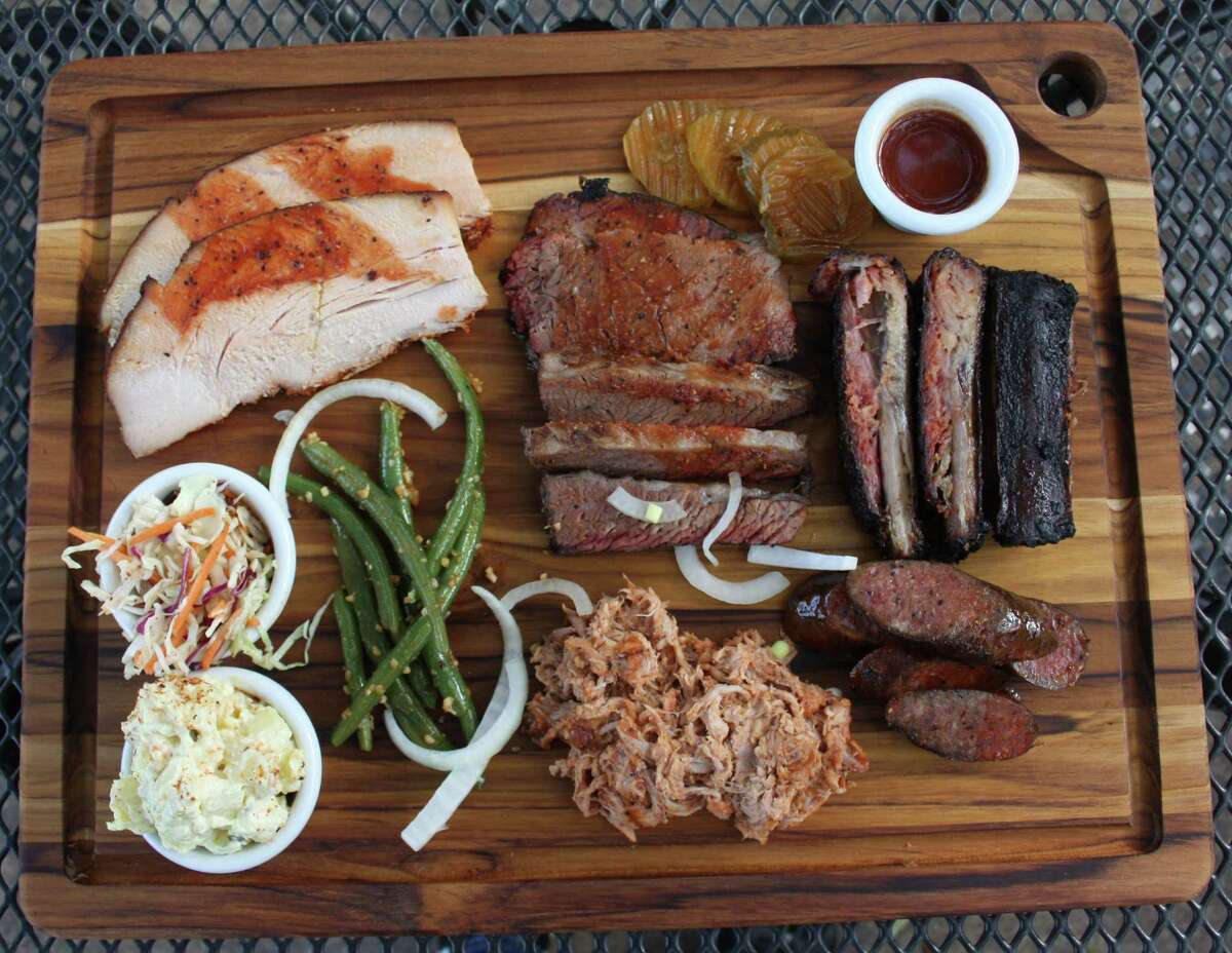 The Bushwood BBQ board consists of (clockwise from top left) smoked turkey, brisket, ribs, sausage, pulled pork, green beans with minced garlic, potato salad and cole slaw.