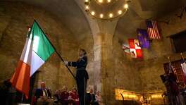 A member of the Lackland Air Force Base Honor Guard tips the Irish flag inside of the Alamo in 2001 in honor of Irish citizens that were killed during the battle of the Alamo. The annual memorial service there also honored Alamo war dead from other countries and numerous states accross America.