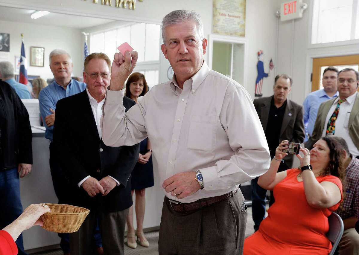Judge Craig Doyal holds up his number one piece of paper as he draws for position on the ballot as his opponent Rep. Mark Keough (behind left) watches at the Montgomery County Republican Party office in Conroe, TX, Dec. 21, 2017. (Michael Wyke / For the Chronicle)