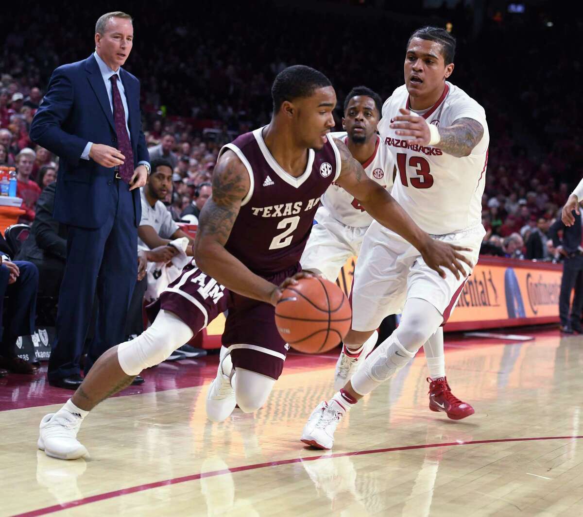 Texas A&M guard TJ Starks tries to get past Arkansas defender Dustin Thomas during the first half of an NCAA college basketball game Saturday, Feb. 17, 2018, in Fayetteville, Ark. (AP Photo/Michael Woods)