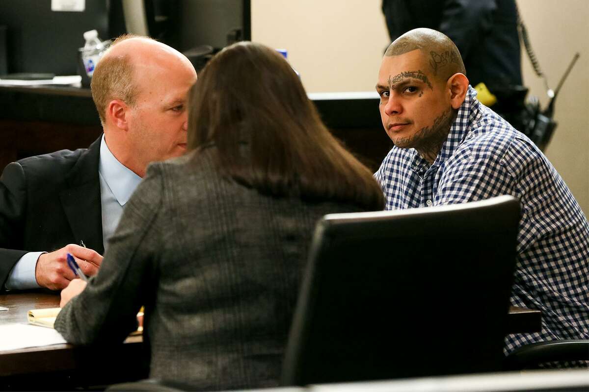 Defendant Gabriel Moreno (right) talks with defense attorneys Albert Gutierrez, Jr. and Kelly Feight.