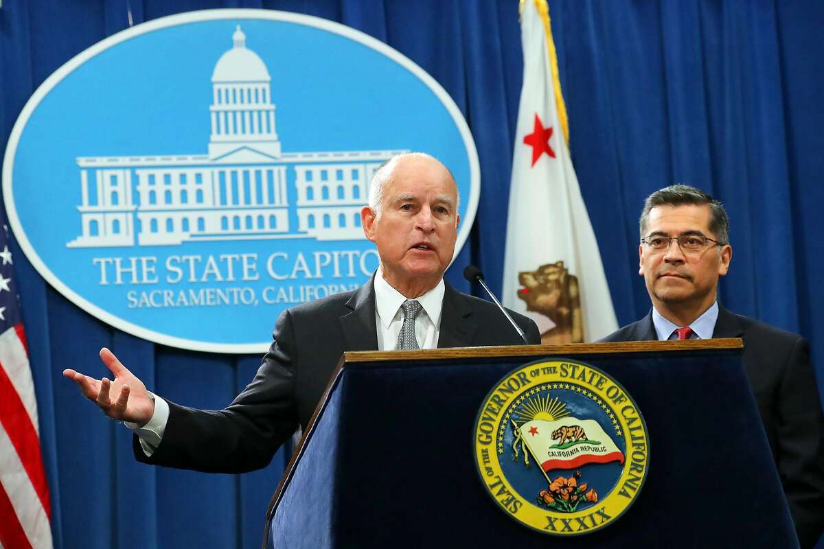 Calif. Gov. Jerry Brown, left, with Xavier Becerra, the state's attorney general, reacts to Attorney General Jeff Sessions immigration lawsuit announcement, in Sacramento, Calif., March 7, 2018. Warning that California’s liberal politicians were endangering the state’s citizens and obstructing federal law, Sessions announced Wednesday that the Trump administration was suing the state over its so-called sanctuary laws. (Jim Wilson/The New York Times)