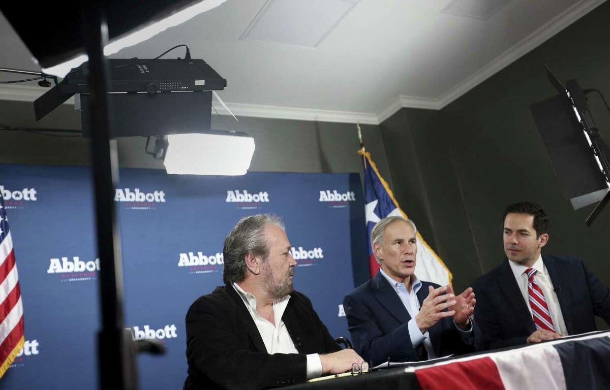 Texas Gov. Greg Abbott, middle, speaks alongside WBAP radio host Rick Roberts, left, and Alex Trevino, Abbott's campaign spokesperson, during a Facebook Live for his office after clinching the Republican nomination for governor during the primary election at the DoubleTree Hotel in Farmers Branch, Texas on Tuesday, March 6, 2018. (Rose Baca/The Dallas Morning News via AP)