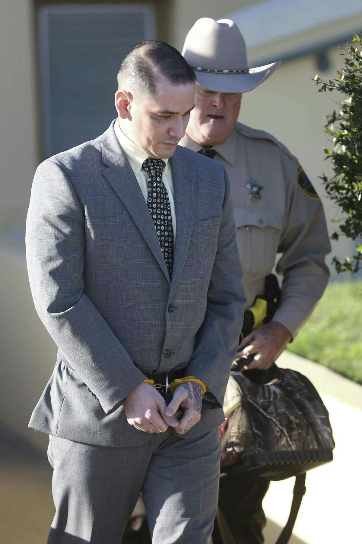 Shaun Ruiz Puente, 36, left, who is accused of shooting and killing SAPD Officer Robert Deckard during a multi-county chase Dec. 8, 2013, is escorted by an Atascosa County Sheriff Deputy back to the Atascosa County Jail after the second day of his capital murder trial Wednesday, March 7, 2017 in the Atascosa County courthouse in Jourdanton. A jury now is deliberating in the case.