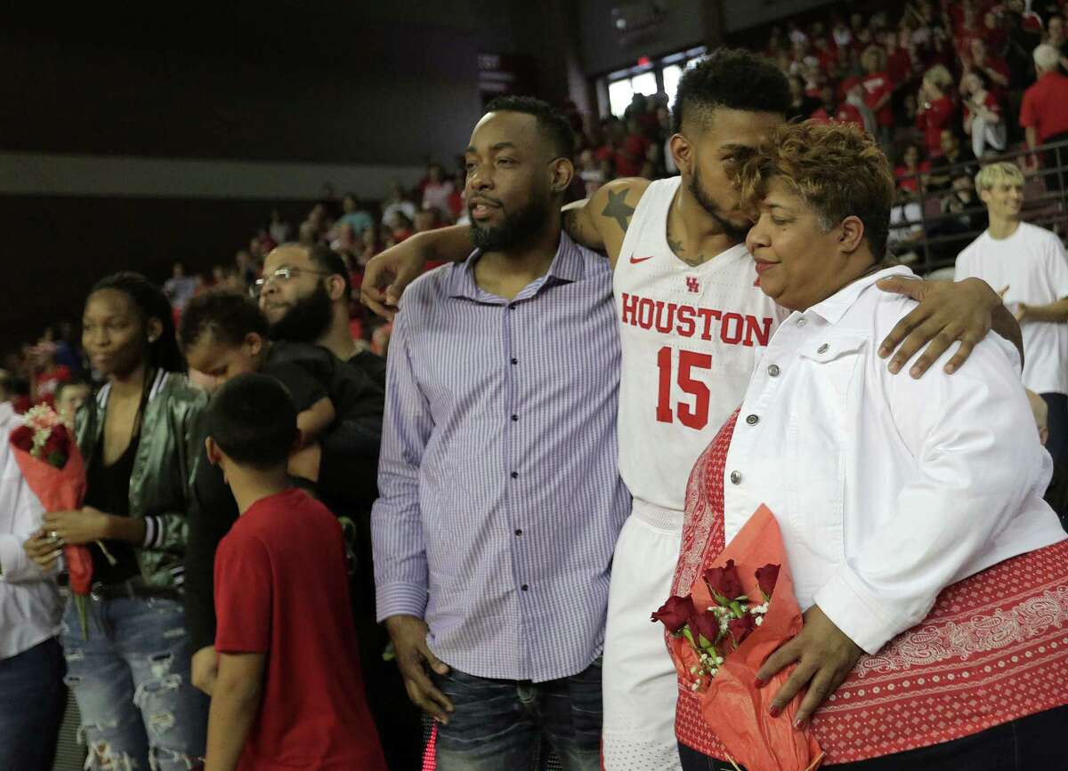 UH forward Devin Davis (15) shares an emotional moment with his mom during senior day Sunday.