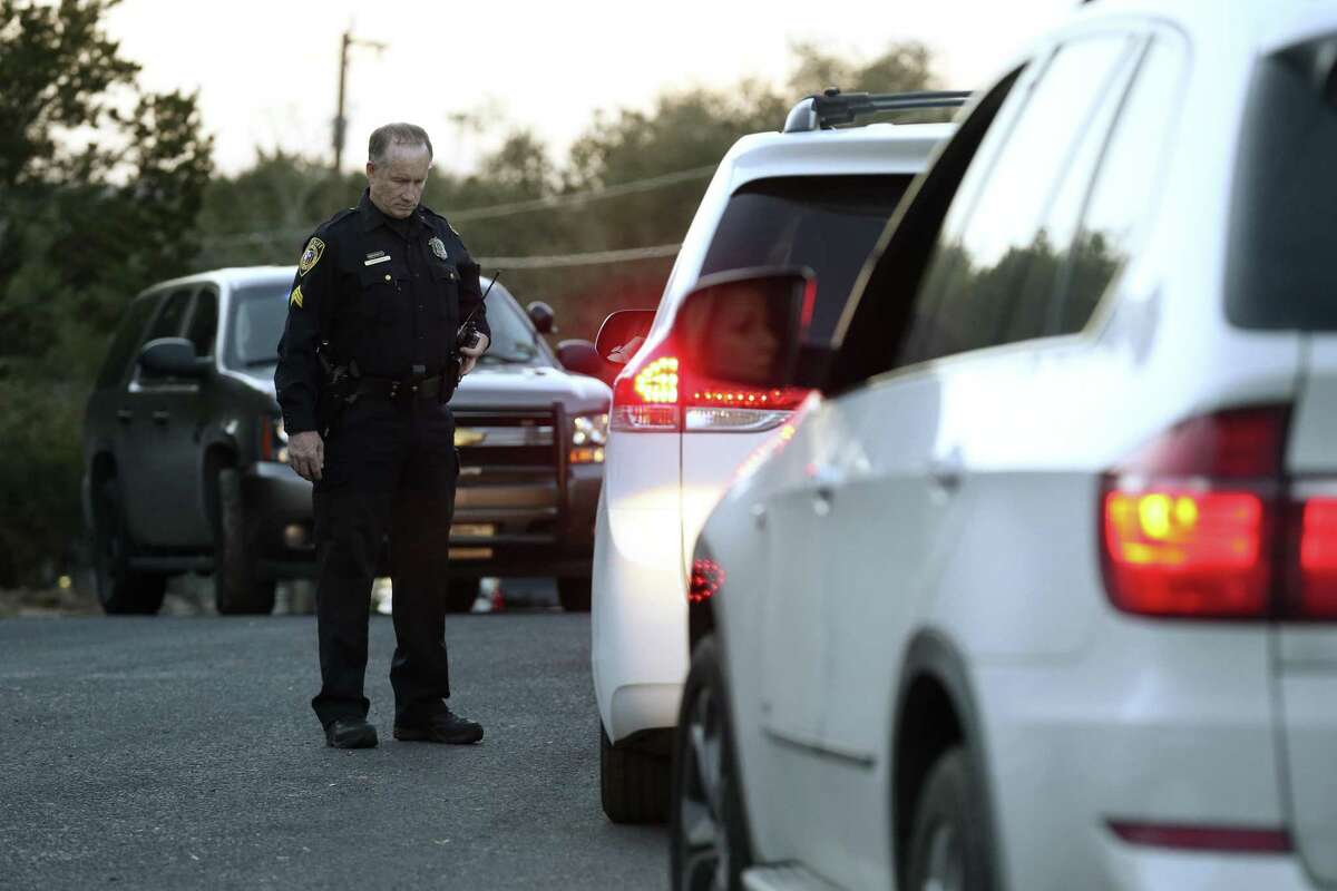 Law enforcement personnel check vehicles Wednesday near the site of a standoff in the Stage Coach Hills subdivision in northwest Bexar County.