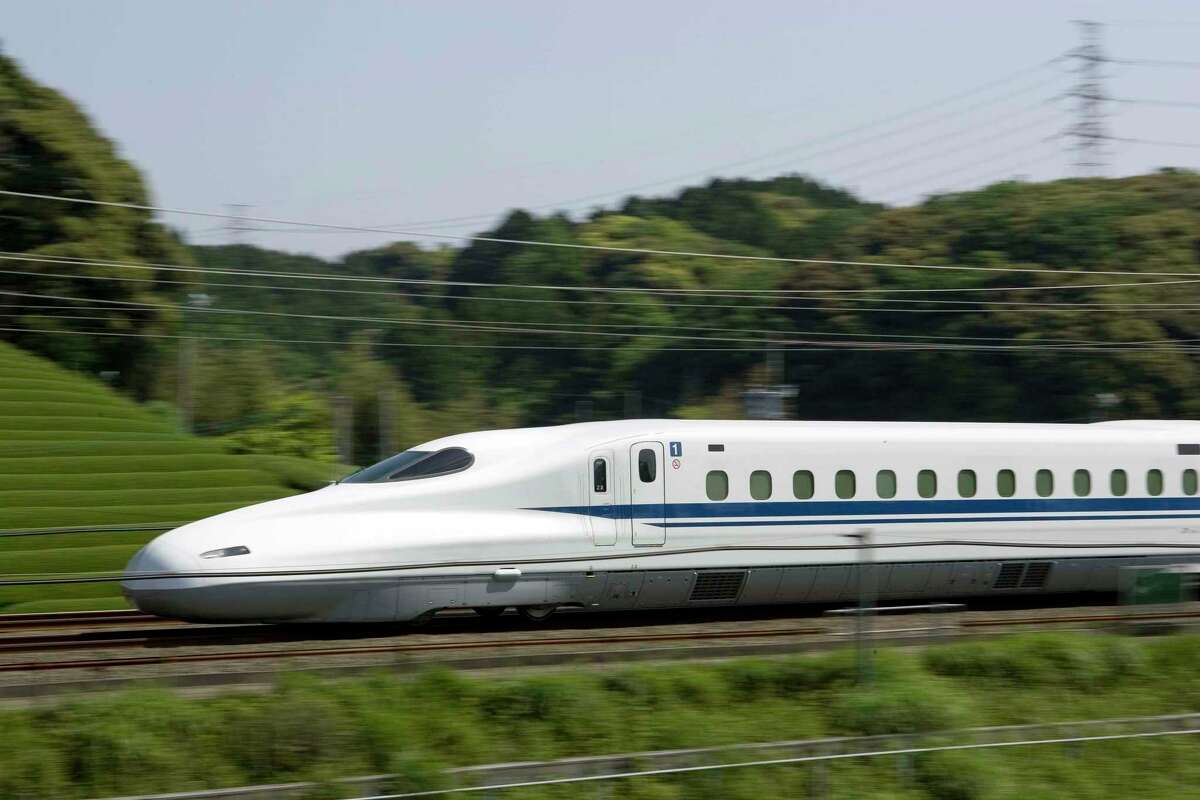 The planned high-speed rail line between Houston and Dallas would use overhead electrical lines and its own separated tracks to shuttle riders between the two metro areas, through mostly flat, rural land. The N700 train is shown in this photo illustration from Texas Central Railway, using images provided by Japan Railway Central.