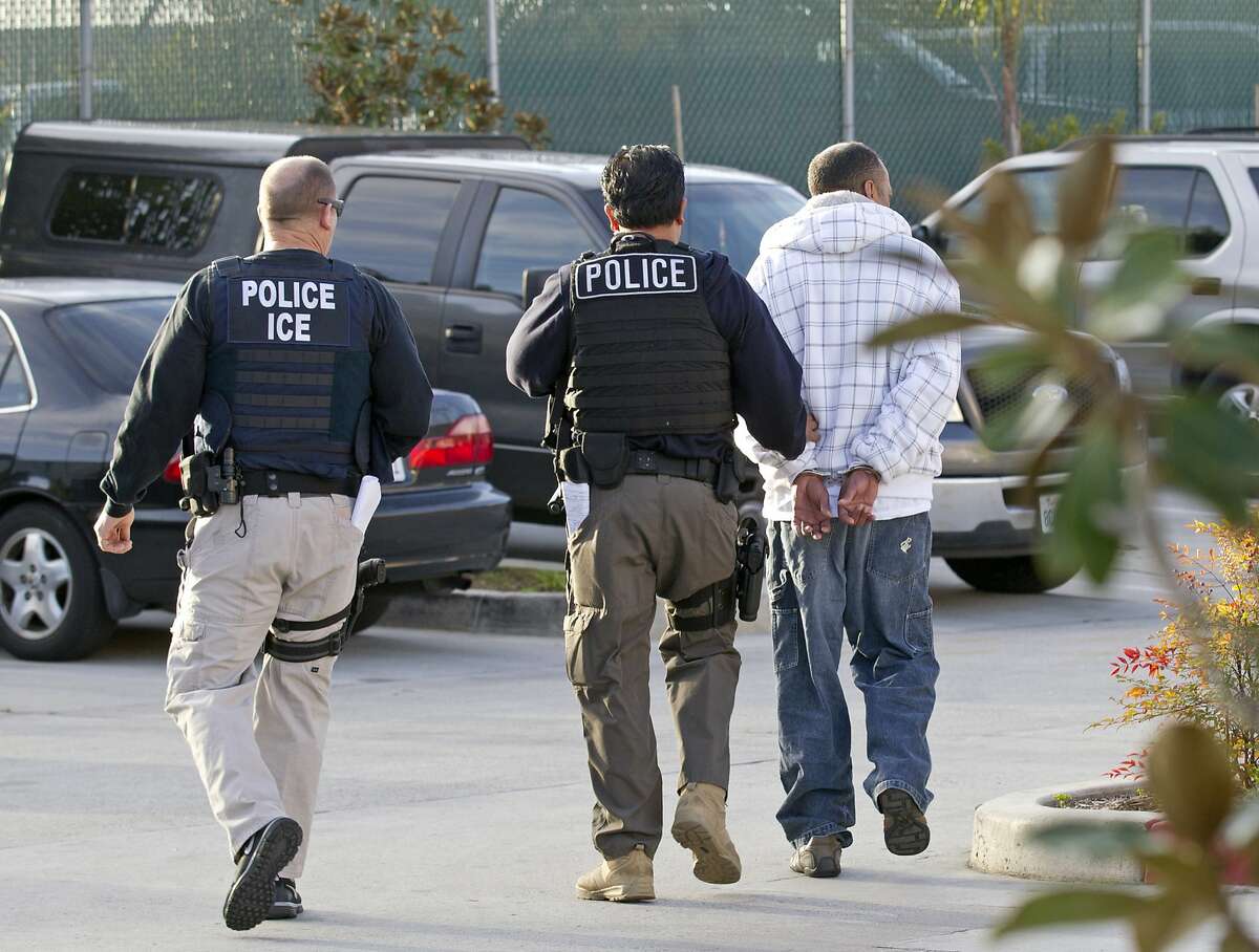 FILE - In this March 30, 2012 file photo, Immigration and Customs Enforcement (ICE) agents take a suspect into custody as part of a nationwide immigration sweep in Chula Vista, Calif. People arrested by deportation officers increasingly have no criminal backgrounds, according to figures released Friday, Feb. 23, 2018, reflecting the Trump administration's commitment to cast a wider net. (AP Photo/Gregory Bull, File)