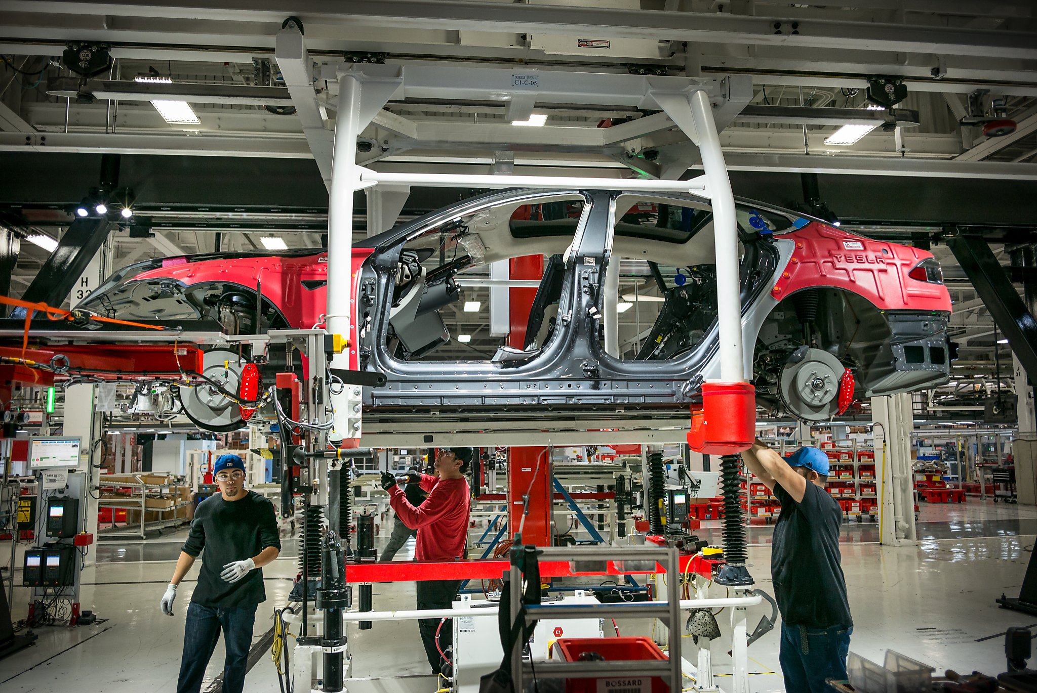  A production line of Tesla cars with workers in the factory.