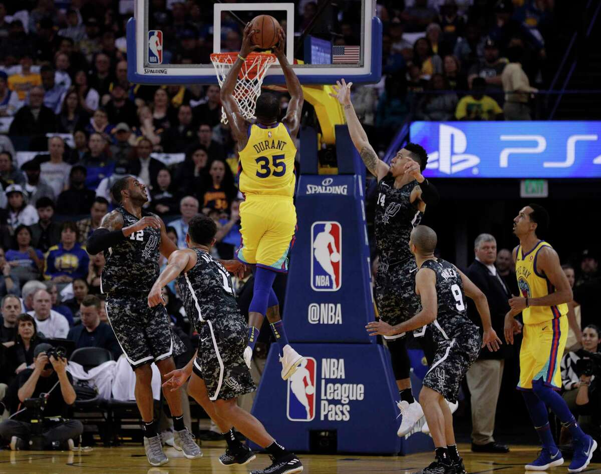 Kevin Durant (35) goes up for a dunk in the first half as the Golden State Warriors played the San Antonio Spurs at Oracle Arena in Oakland, Calif., on Thursday, March 8, 2018.