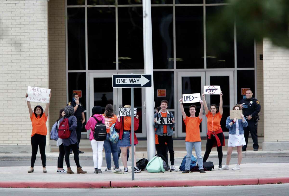 A group of student at Brandeis High School hold up signs in front of the school, advocating school safety and gun control, on Friday, March 9, 2018.