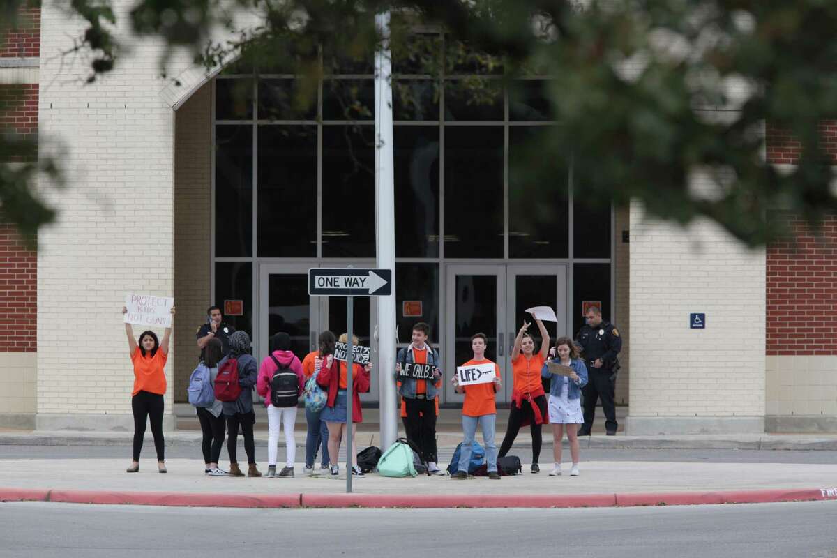 A group of student at Brandeis High School hold up signs in front of the school, advocating school safety and gun control, on Friday, March 9, 2018.