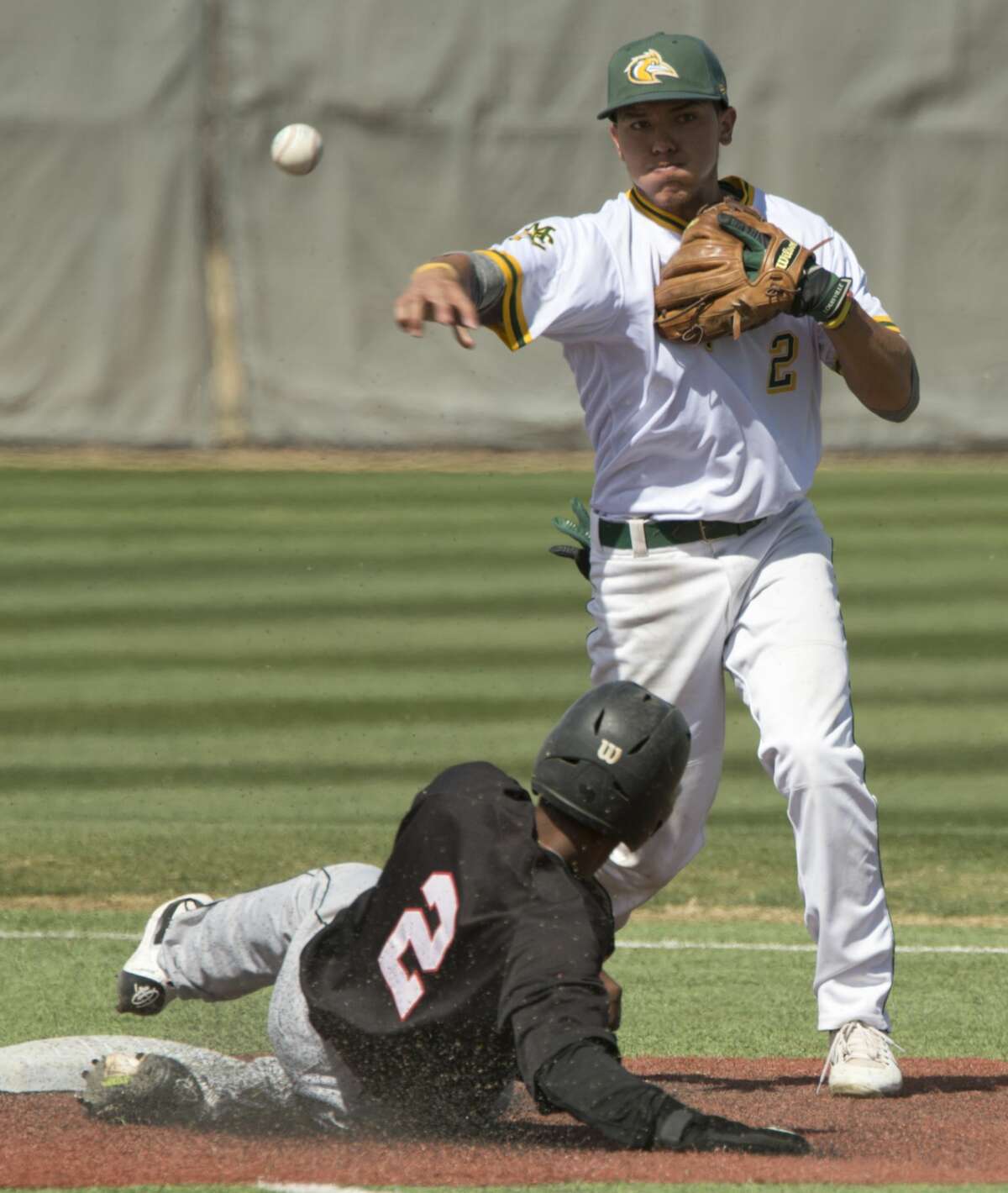 Midland College's Frainyer Chavez gets the force out at second on Howard College's Jaxon Williams and makes the double play to first 03/09/18 in the first game of a double header at Christensen Stadium. Tim Fischer/Reporter-Telegram
