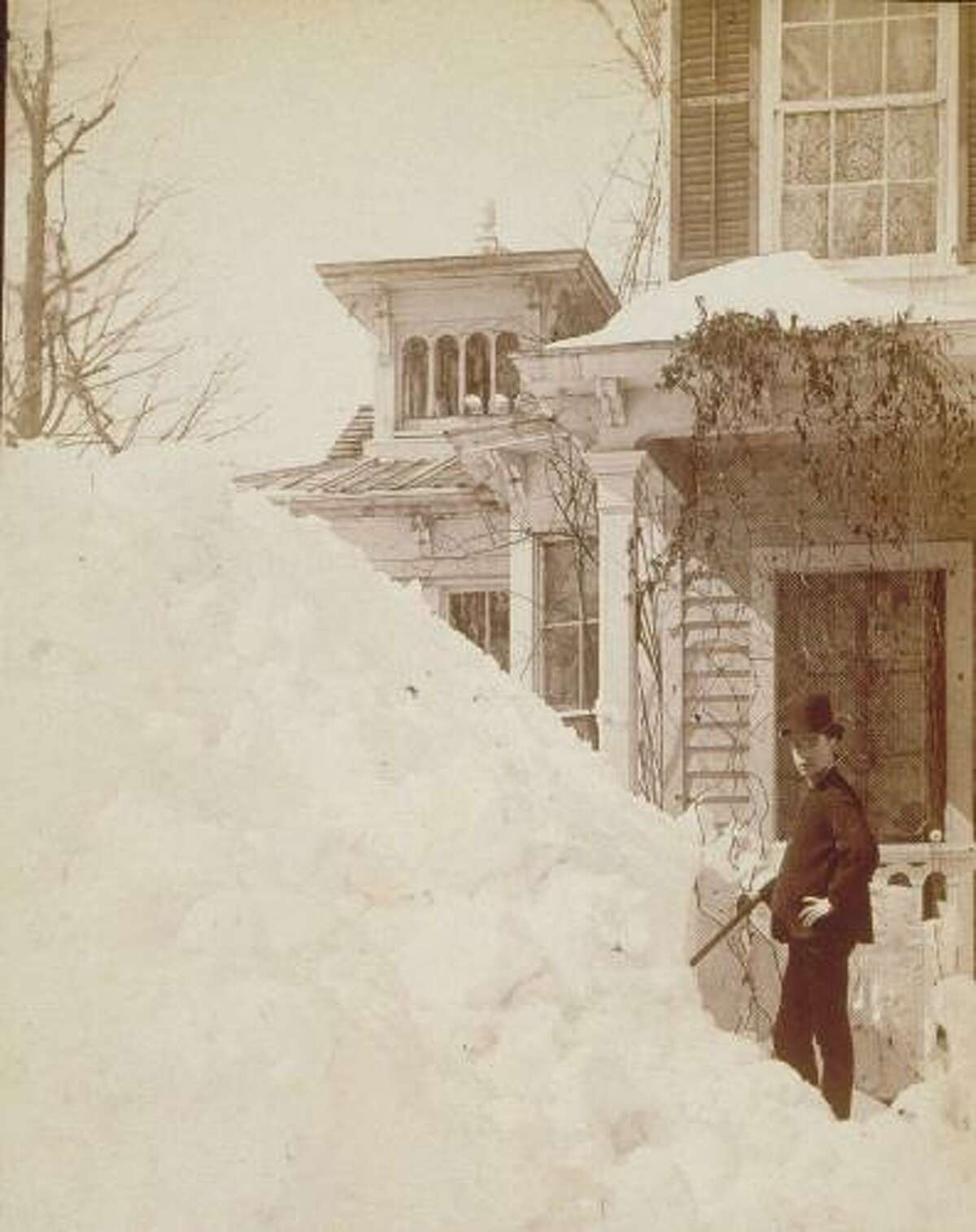 A young man stands beside a large pile of snow at 380 Main St., Danbury, after the Blizzard of 1888, which started on March 12.
