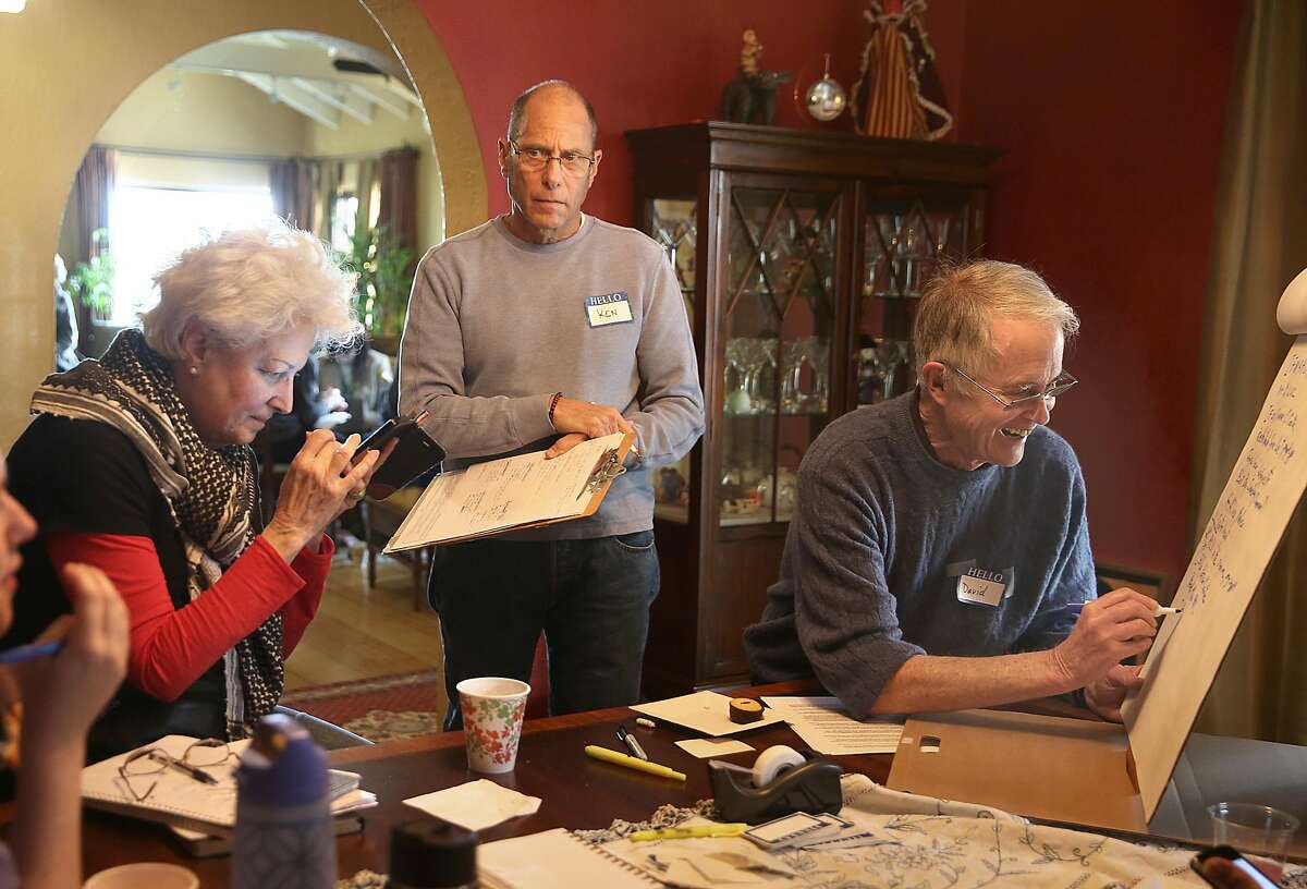 Left to right--Sharon Rose, David Johnston, and Ken Richard, Miguel Espino talk about community outreach at Rodrigo Torres' home on Friday, March 9, 2018, in Oakland, Calif.