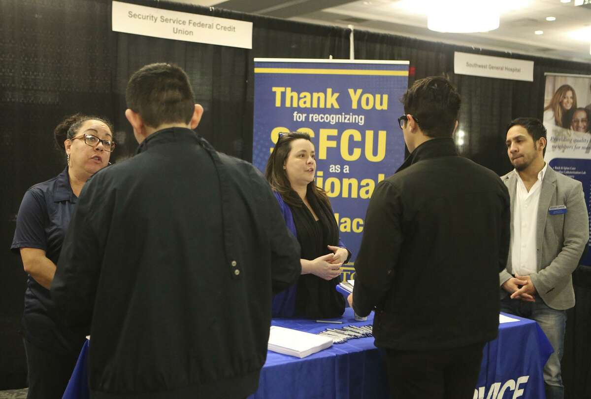 Valerie Siller (left, facing) Melissa Medley (center, facing) and Adrian Torres (right, facing) answer questions about employment opportunities at Security Service Federal Credit Union during a Mega Career Fair at the Norris Conference Center on Loop 410.